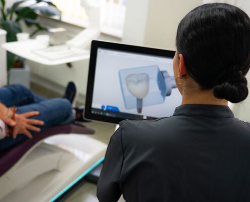 Patient im Zahnarztstuhl wird vom Zahnarzthelferin über bevorstehende Behandlung aufgeklärt